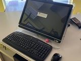 un ordinateur portable posé sur un bureau, avec un clavier et une souris
