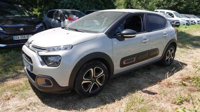 une voiture argentée garée dans un champ avec d'autres voitures