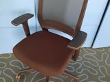 une photo d'une chaise de bureau marron posée sur un tapis
