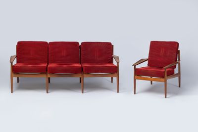 deux canapés rouges et un fauteuil dans une pièce aux murs blancs