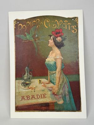 une vieille carte postale représentant une femme en robe bleue assise à une table