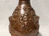 a brown vase sitting on a table with a white background