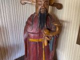 une statue représentant un homme tenant un marteau, posée sur une table