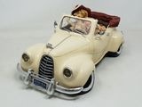a figurine of a woman driving a car with a dog in the back seat