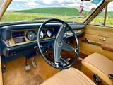 a steering wheel and dashboard of a car with a view of a field