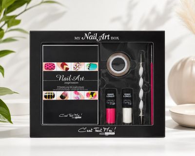 Le kit de nail art se trouve sur une table, à côté d'une plante en pot
