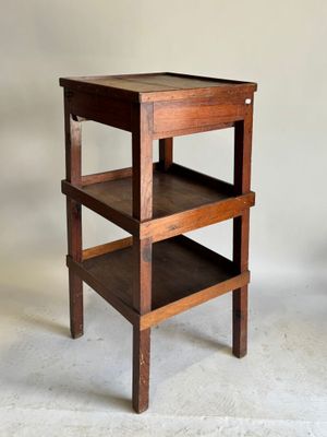 une petite table en bois sur laquelle sont posées trois étagères