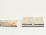 un petit étui à cigarettes en argent et un petit étui à cigarettes en argent
