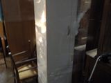 un grand réfrigérateur blanc posé dans une pièce où se trouve une chaise