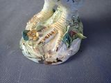 a figurine of a woman sitting on a bench