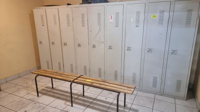 a bench in the middle of a room with lockers in the background