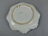 a white plate with a gold rim on a table