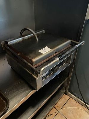 a grill that is sitting in the corner of a kitchen