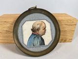 an old picture of a man in a blue shirt is hanging on a wooden plaque