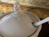 a white bowl with a lid and a spoon in it