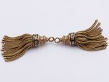 a pair of gold toned tassels with black beads