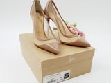 a pair of nude colored high heels sitting on top of a cardboard box