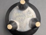 a small black vase with a writing on it