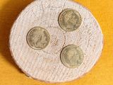 three coins sitting on top of a piece of wood