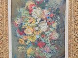 tableau représentant un vase de fleurs dans un cadre doré posé sur une table