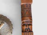 a wooden pole with a carving on it next to a bowl