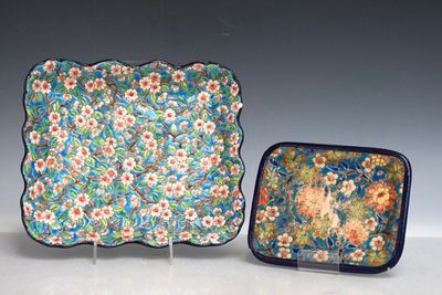 deux assiettes et un plateau orné de fleurs, posés sur une table