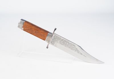 un couteau avec un manche en bois sur une surface blanche