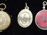 four antique silver and gold oval lockes on a black background
