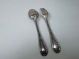 pair of silver plated spoons and fork on a white surface