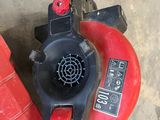a red gas can with a blower attached to it