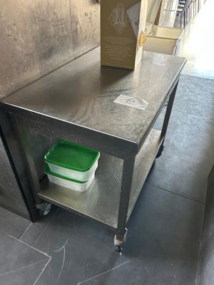 une table en métal sur laquelle est posé un récipient vert