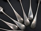 six spoons and a fork on a black surface