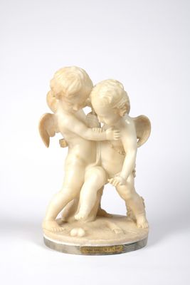 two small figurines of cherenshes holding hands on a white surface