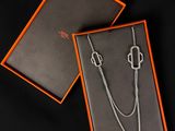 an orange box with a silver necklace and a silver chain