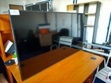 un bureau avec un écran et une chaise dans la pièce