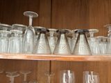 many empty glasses on a shelf in the kitchen
