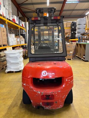 un chariot élévateur rouge garé dans un entrepôt