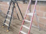 Plusieurs échelles sont alignées contre un mur de briques dans un immeuble