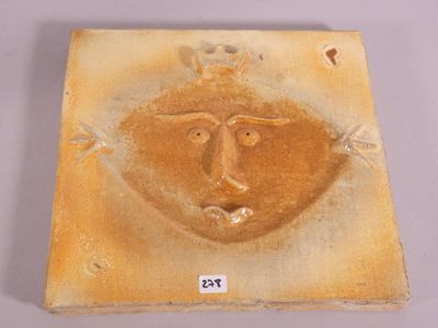 a picture of a ceramic plaque with a face on it