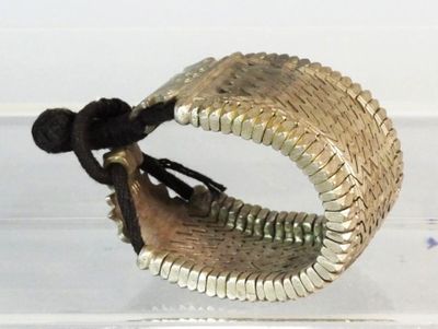 a silver bracelet with a black cord on it