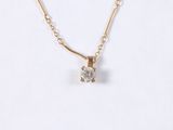 a close up of a necklace with a diamond on a chain