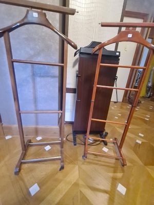 deux portants en bois avec des vêtements suspendus, dans une pièce