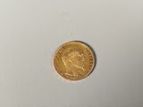 a close up of a gold coin on a white surface