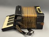 a black and gold accordion sitting on top of a white table