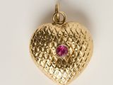 une image représentant un pendentif en or en forme de cœur orné d'une pierre rose