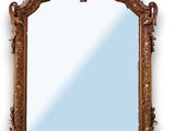 un miroir richement sculpté sur fond blanc, avec un ciel bleu en arrière-plan