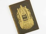 un vieux livre à la couverture dorée posée sur un fond blanc