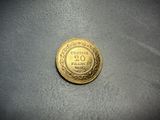 a close up of a gold coin on a gray surface