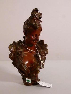 une petite statue représentant une femme avec un oiseau sur la tête