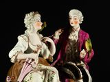 a figurine of a man and a woman sitting next to each other